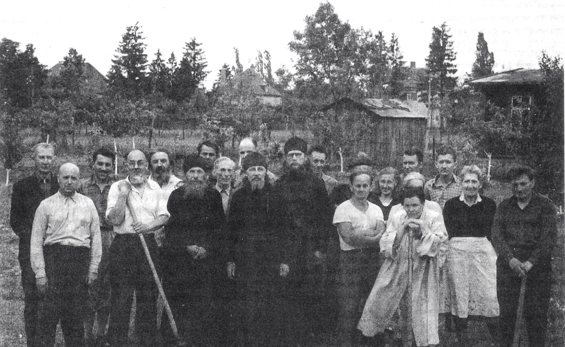 У перерві між роботами на городі. Архім. Іов (в центрі), о. Корнилій (праворуч від нього) і о. Павел (ліворуч від о. Іова) з друзями і помічниками Обителі, серед котрих: директор мюнхенської гімназії П. Д. Іл’їнський (з вилами в руках),Скоржинський, Н. А. Цуриков, Іоанн (з киркою; серб, про котрого згадується в тексті), д- р Ганна Кузнецова – Буданова, А. П. Бабенко. (Фотографія середини 50 – х рр.)